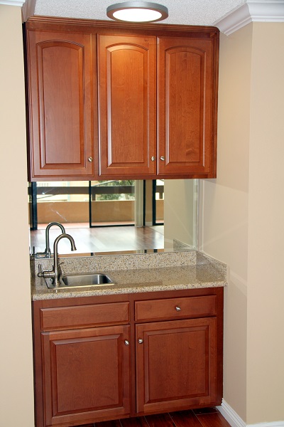 Living Room wet bar with custom cherry wood cabinets and granite counters