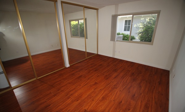 Very Large bedroom with hardwood floors and mirrored closet doors