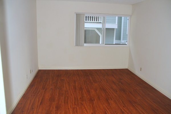 Very large bedroom with hardwood floor and mirrored Closet Doors